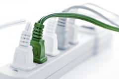 4 white and 1 green plugs in a power strip